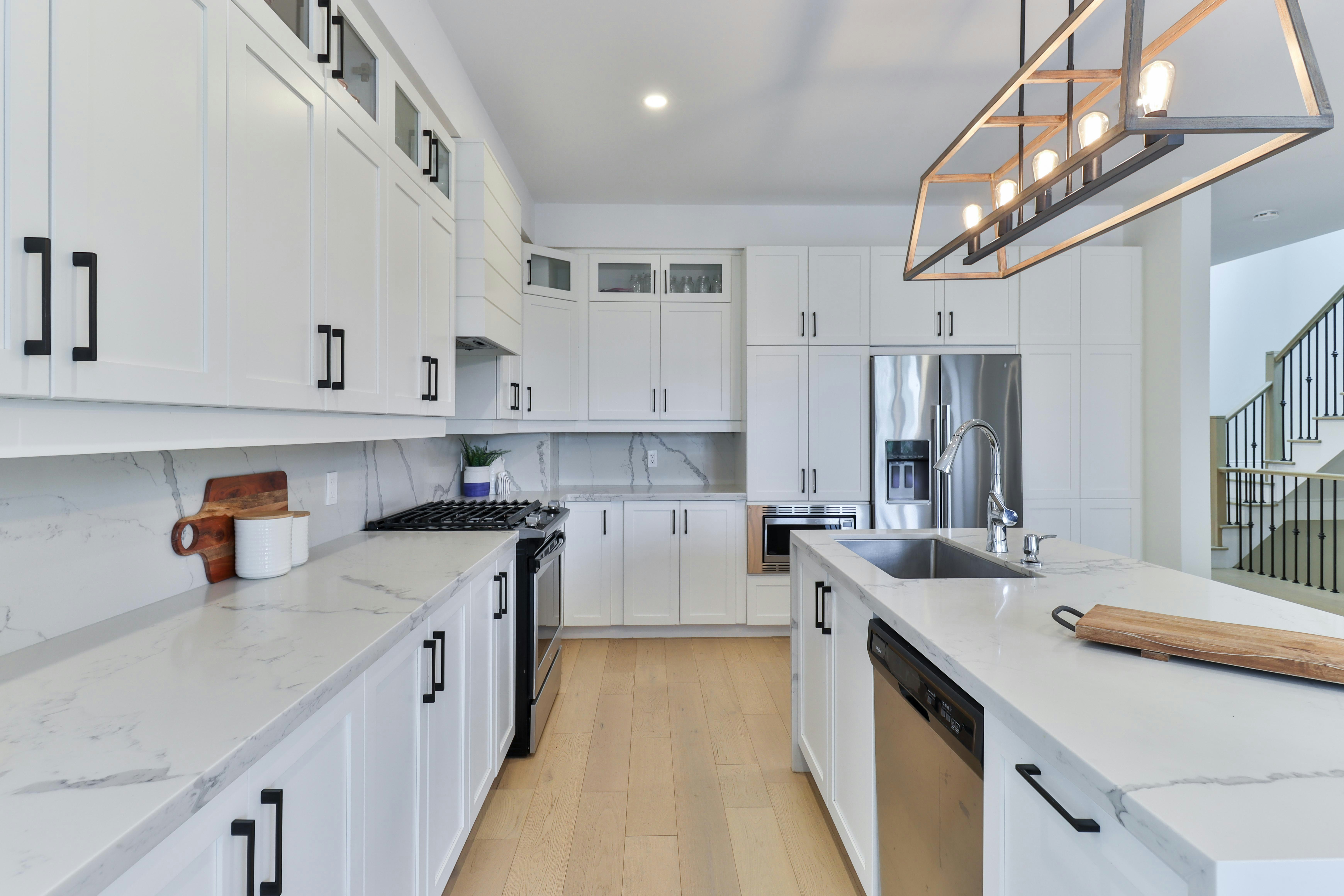 Modern finished kitchen with white cabinets, wood countertops, and built-in appliances by V-Clair